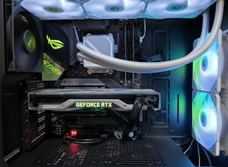 A high-end gaming or performance PC interior equipped with RGB lighting and multiple cooling fans. The graphics card prominently displayed is a GeForce RTX model, with branding visible. The setup includes neatly managed cables and a liquid cooling system.